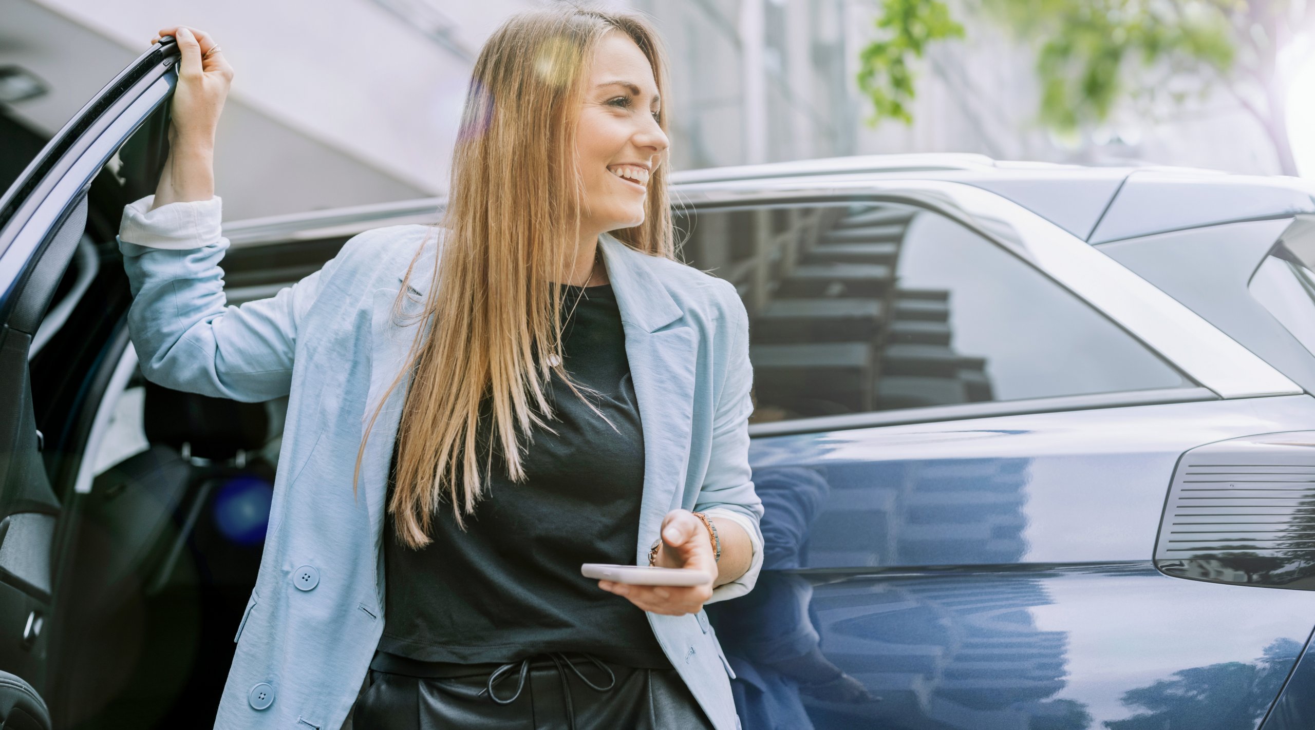 Glad kvinde i bymiljø bruger APCOA PARKING til nem og fleksibel parkering 